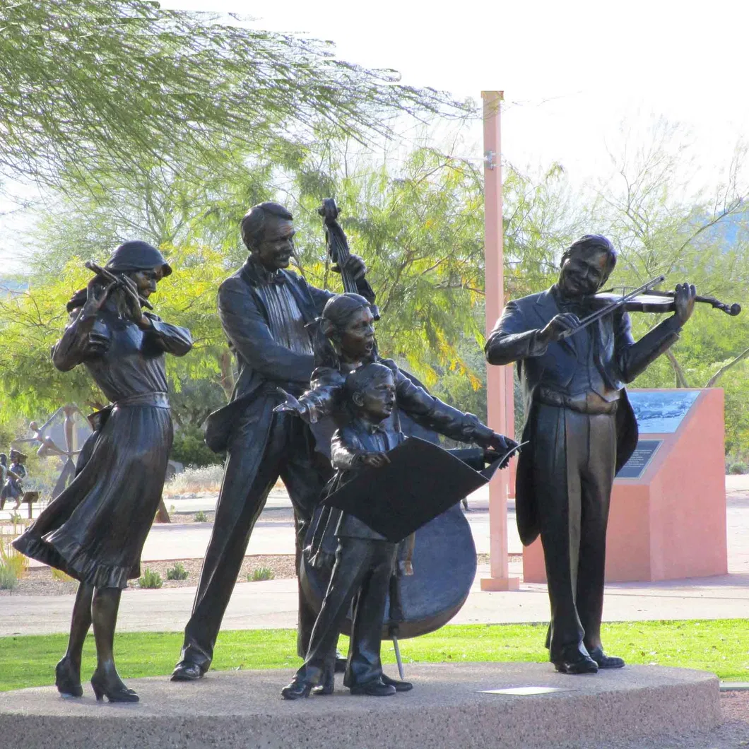 Copper Statue Three Musicians Playing Instruments and Two Children Singing Songs on a Park